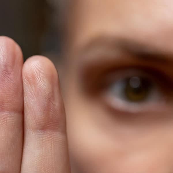 Close-up of a person's eye tracking two raised fingers, illustrating EMDR eye-movement therapy